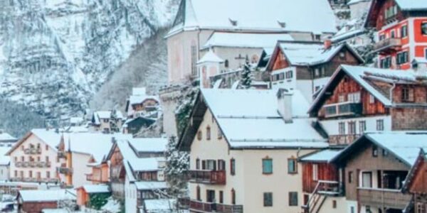 Snowy Hallstatt, Austria in front of a mountain, reflected in the icy lake.