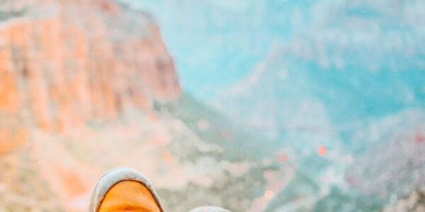 Close up of man wearing mountain boots and landscape of mountains in Zion National Park.