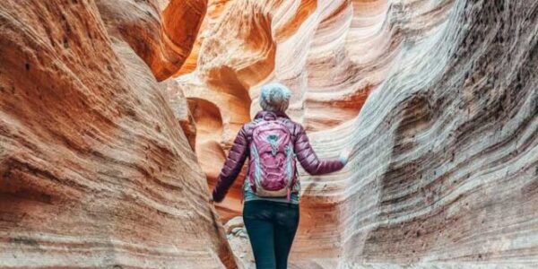 Jenny with a back to the camera hiking the Narrows at Zion National Park in Utah