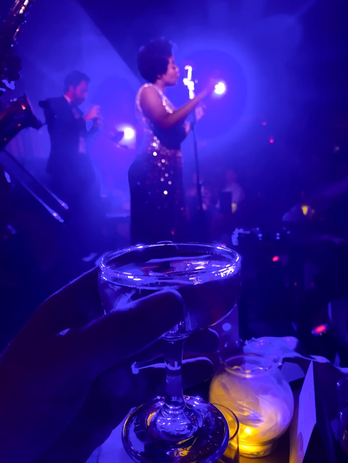 glass of champagne and woman singing at sleep no more new york city